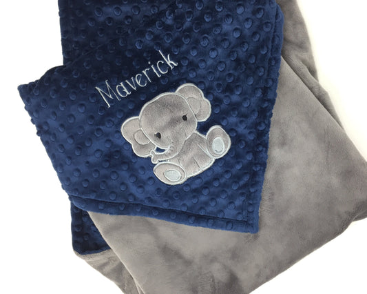 Baby blanket with a gray elephant applique and name in gray. This blanket has navy dimple dot on one side with the elephant and name. The other side is smooth graphite gray minky. This is a beautiful soft blanket for baby to snuggle.