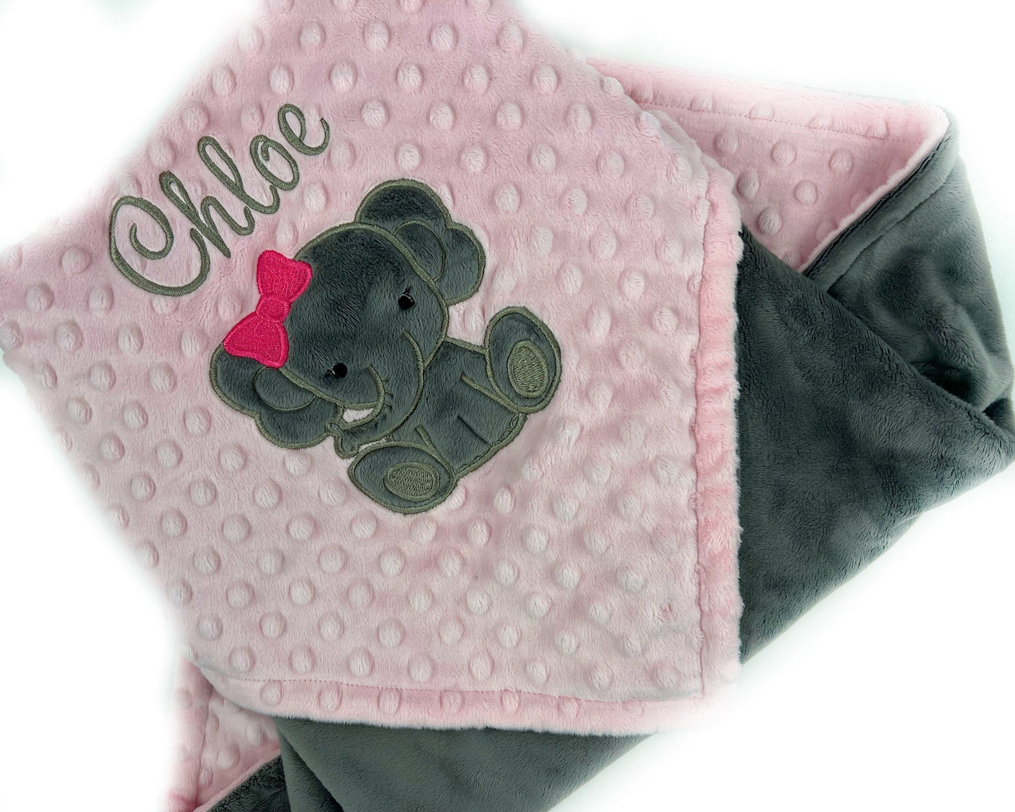 Baby blanket with a gray elephant applique and name in gray. This blanket has blush pink dimple dot on one side with the elephant and name. The other side is smooth graphite gray minky. This is a beautiful soft blanket for baby to snuggle.